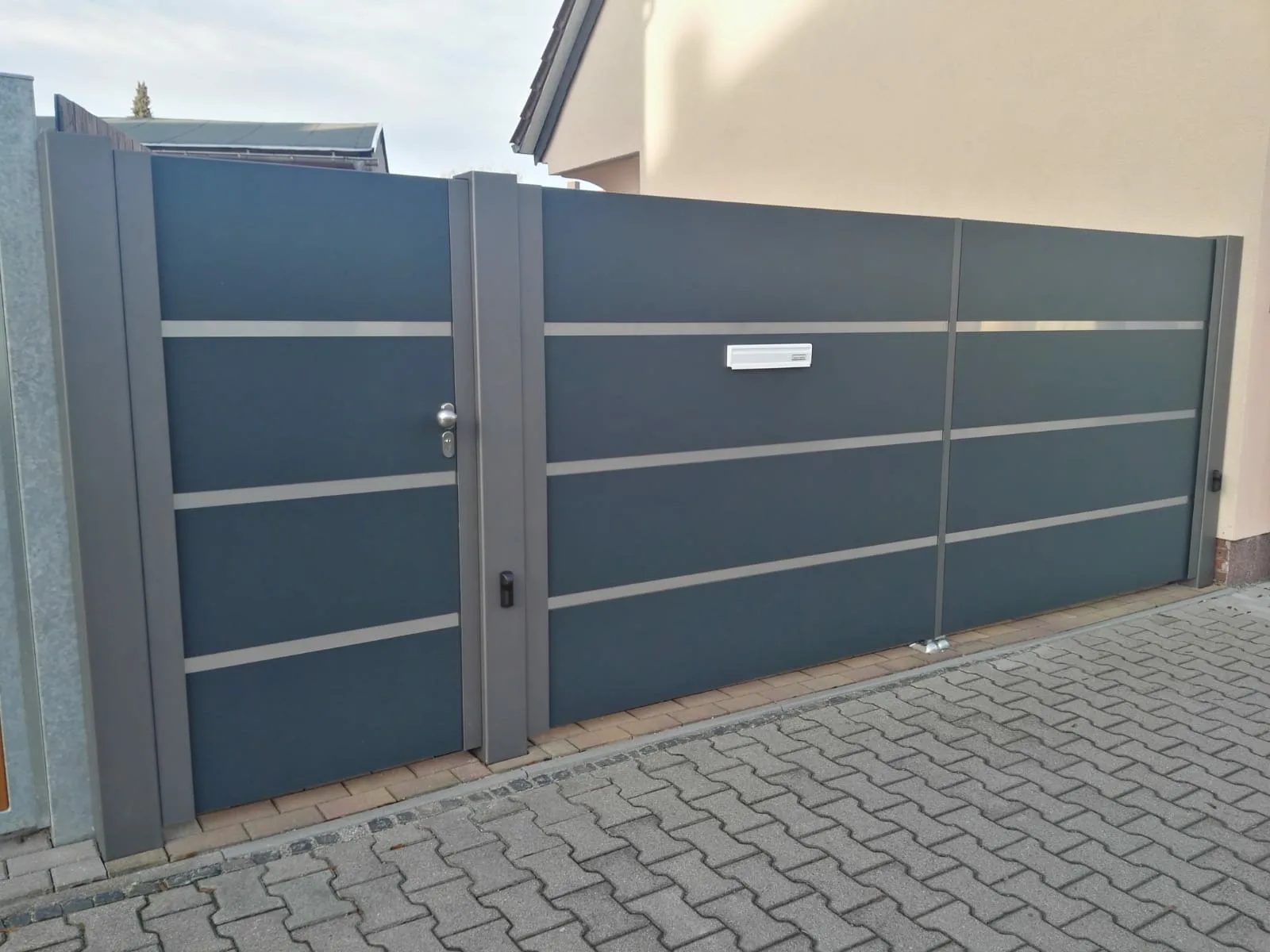 Dreflügeltoranlage Trespa mit Edelstahlstreifen